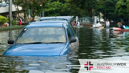 A blue car submerged in flood waters