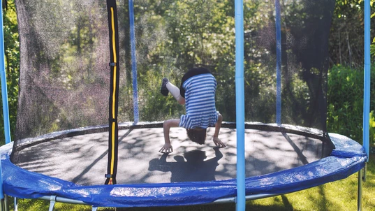 boy jumping on trampoline. a child is tumbling on a trampoline