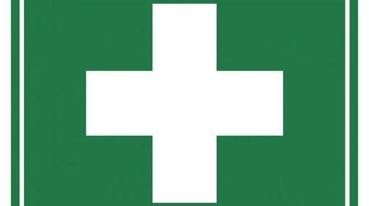First aid sign with white cross on green background