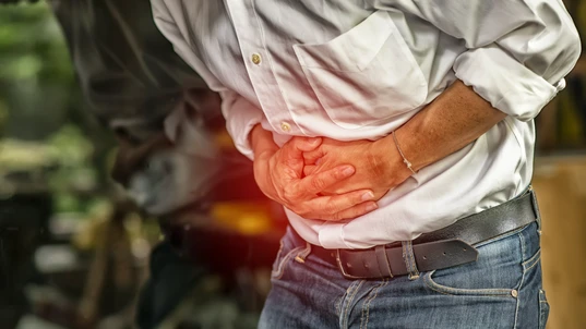 Man with abdominal pain clutching his stomach