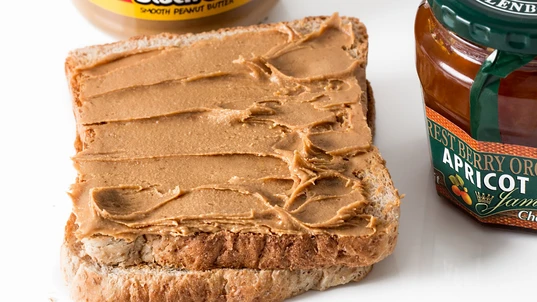peanut butter spread on a slice of bread