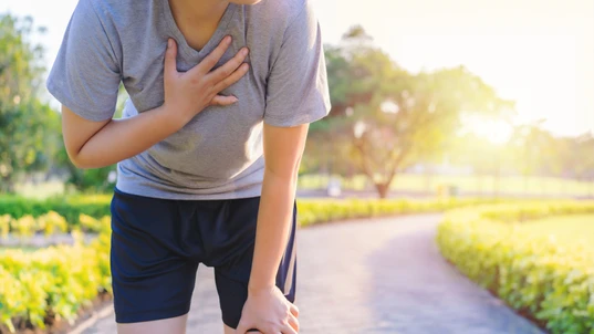Woman have chest pain while running in the garden.